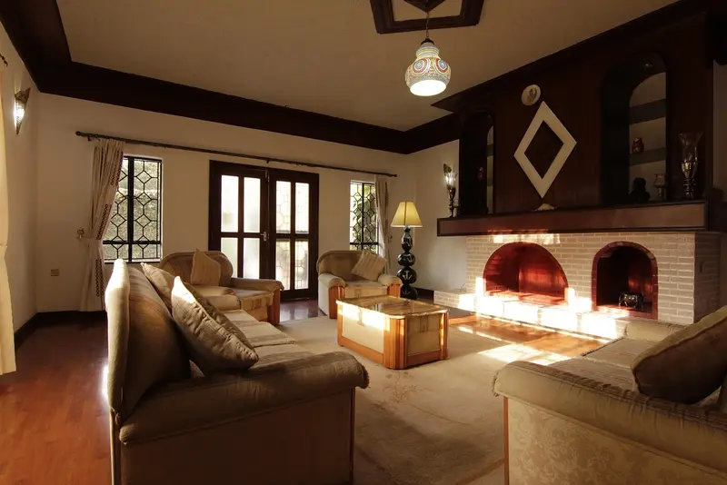 A luxurious living room in a hotel, featuring a sofa, fireplace, and a view of the outside, symbolizing hotels in San Antonio.